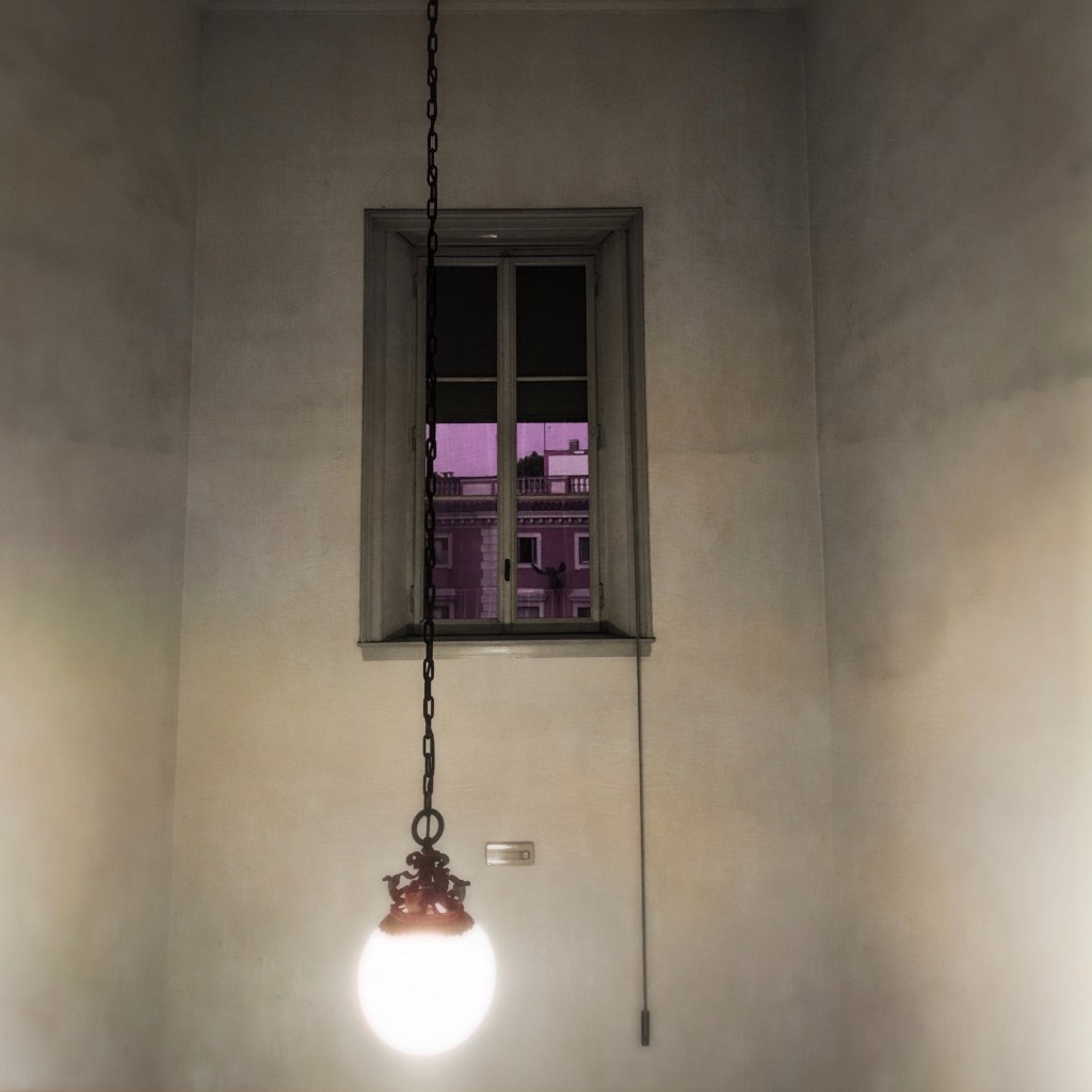 An Ornamental Light Glows Beneath the Tinted&nbsp;Window